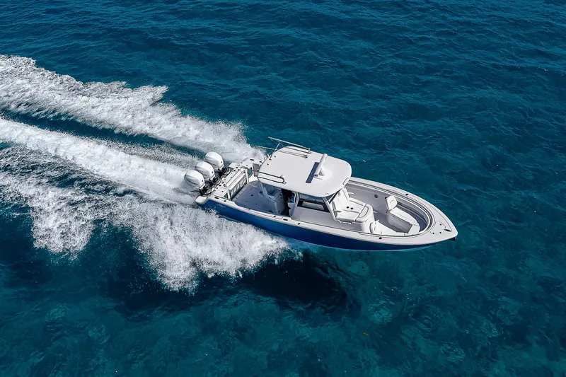 Slide: The Image of 2023 Sportsman Open 352 Center Console boat cruising on clear blue water. - 32