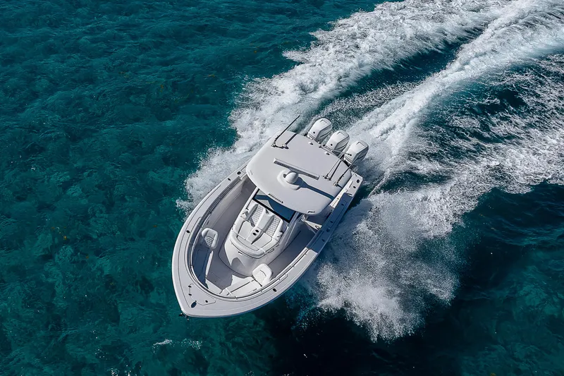 Slide: The Image of 2023 Sportsman Open 352 Center Console boat cruising on clear blue water. - 33