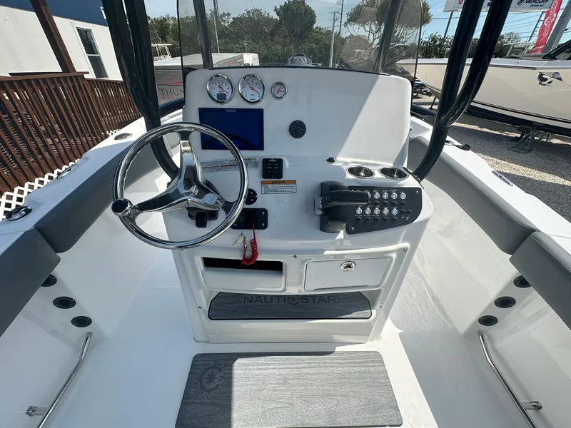 Slide: The Image of 2024 NauticStar 222 OSL boat console with steering wheel, gauges, and controls. - 10