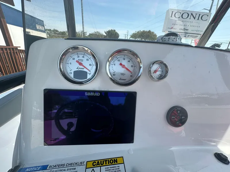 Slide: The Image of Dashboard of a 2024 NauticStar 222 OSL boat with gauges and Simrad display. - 11