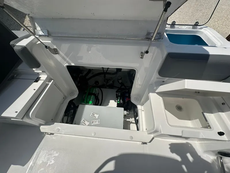 Slide: The Image of 2024 NauticStar 222 OSL boat interior with open storage compartments and engine bay. - 19
