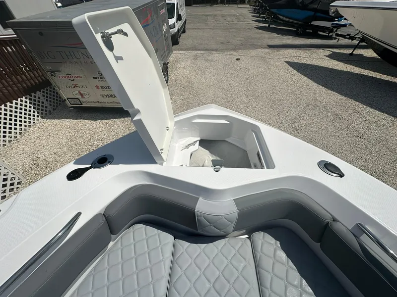 Slide: The Image of 2024 NauticStar 222 OSL boat with open storage compartment and cushioned seating. - 3