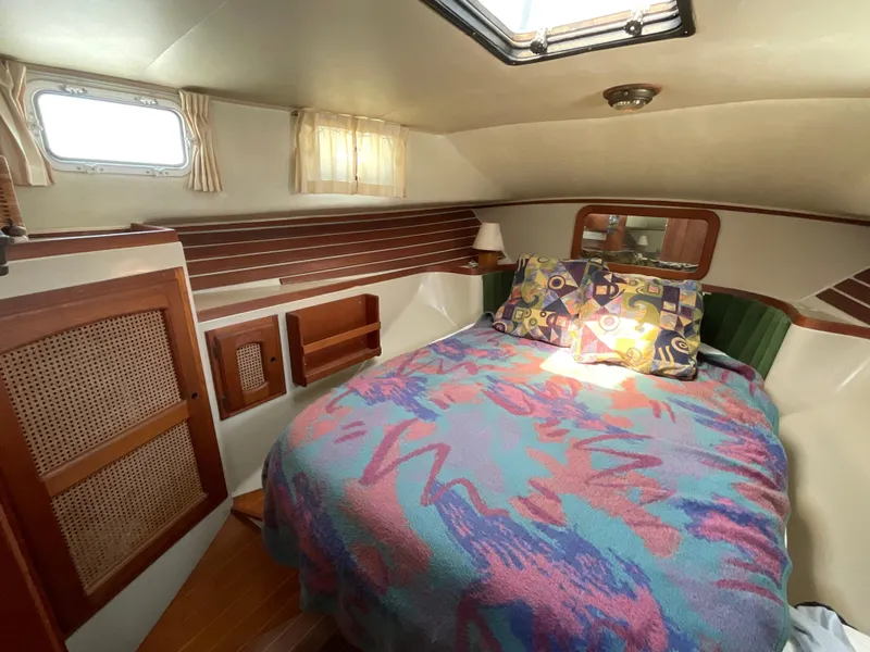 Slide: The Image of Cozy cabin interior of 1983 Lancer 40 yacht with colorful bedding and wooden accents. - 13