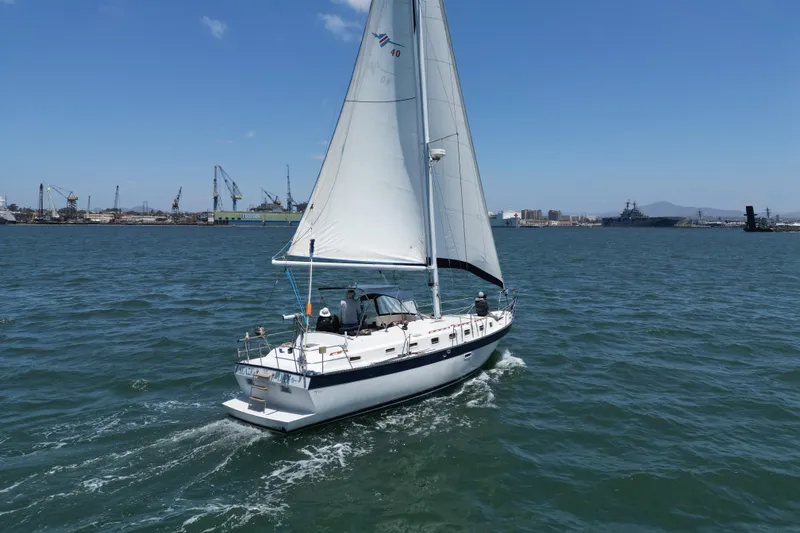 Slide: The Image of Sailing yacht Lancer 40 (1983) cruising in a harbor with industrial background. - 3