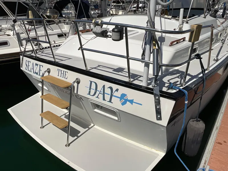 Slide: The Image of 1983 Lancer 40 sailboat docked, featuring "Seize the Day" on the stern. - 6