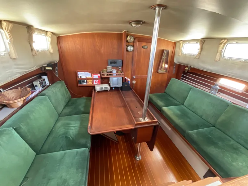 Slide: The Image of Interior of a 1983 Lancer 40 sailboat with green seating and wooden finishes. - 8