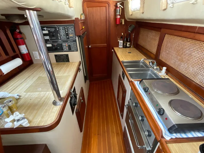 Slide: The Image of 1983 Lancer 40 yacht interior with wooden flooring, kitchen appliances, and control panels. - 9