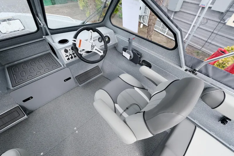 Slide: The Image of 2024 KingFisher 1825 Falcon boat interior with steering wheel and captain's chair. - 11