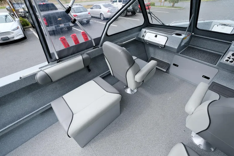 Slide: The Image of 2024 KingFisher 1825 Falcon boat interior with gray seating and dashboard. - 9