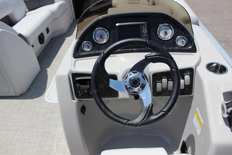 Slide: The Image of 2023 SunCatcher Fusion 324 RC boat dashboard with steering wheel and control panel. - 10