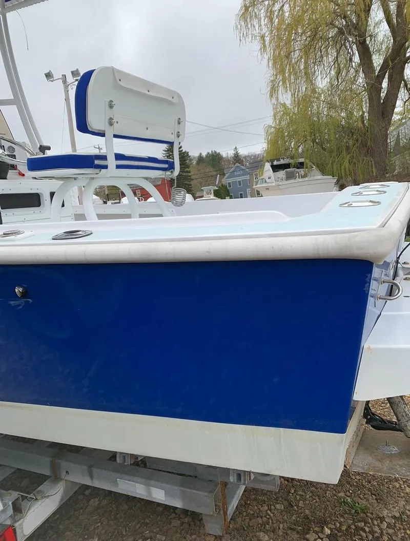 Slide: The Image of 1980 Mako 23 boat with blue and white exterior, parked on a trailer. - 14
