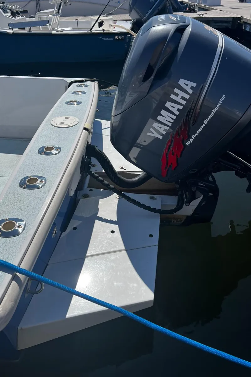 Slide: The Image of 1980 Mako 23 boat with Yamaha outboard motor, docked in marina. - 16