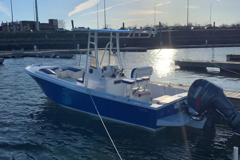 Slide: The Image of 1980 Mako 23 boat docked in a marina, featuring a blue hull and Yamaha outboard motor. - 2
