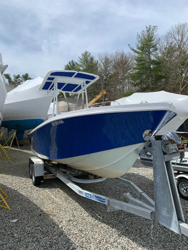 Slide: The Image of 1980 Mako 23 boat on trailer, blue hull, parked outdoors. - 4