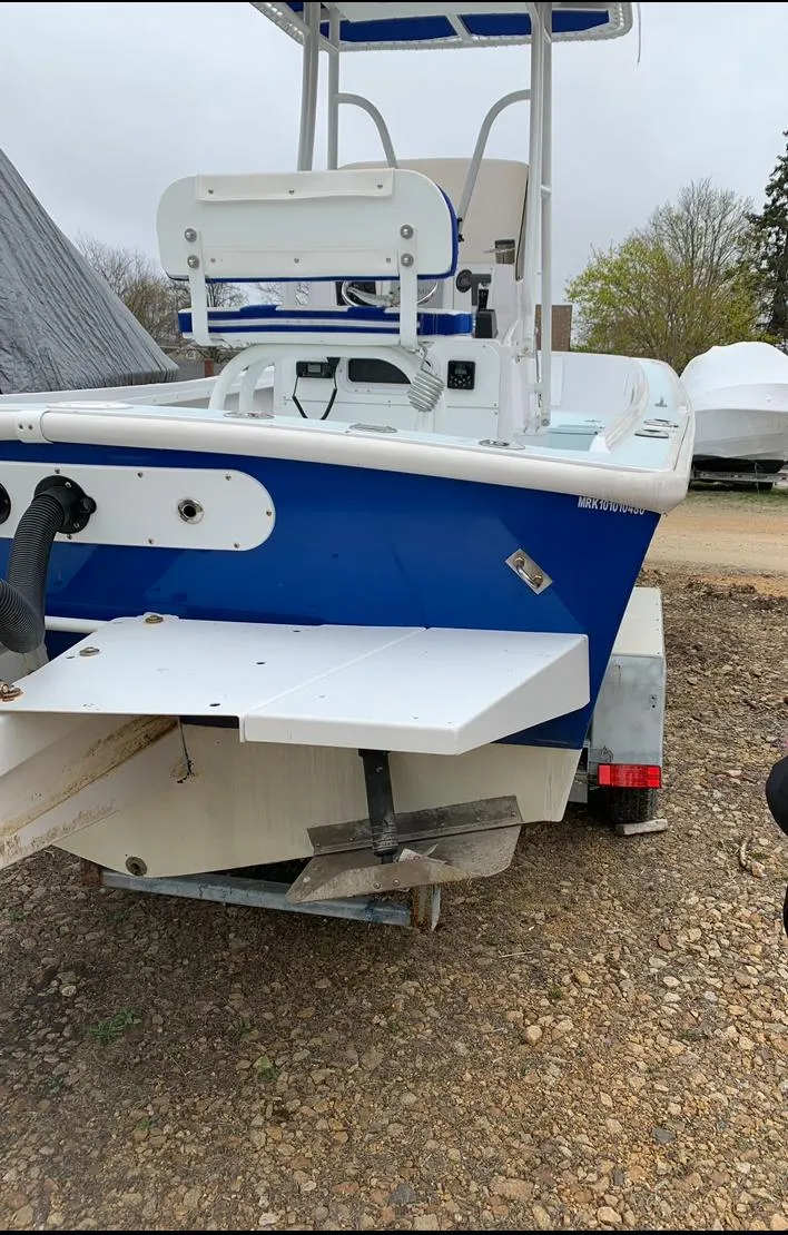 Slide: The Image of 1980 Mako 23 boat on trailer, blue and white, rear view. - 5