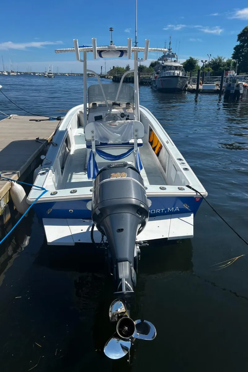 Slide: The Image of 1980 Mako 23 boat docked at marina, featuring outboard motor and clear skies. - 6