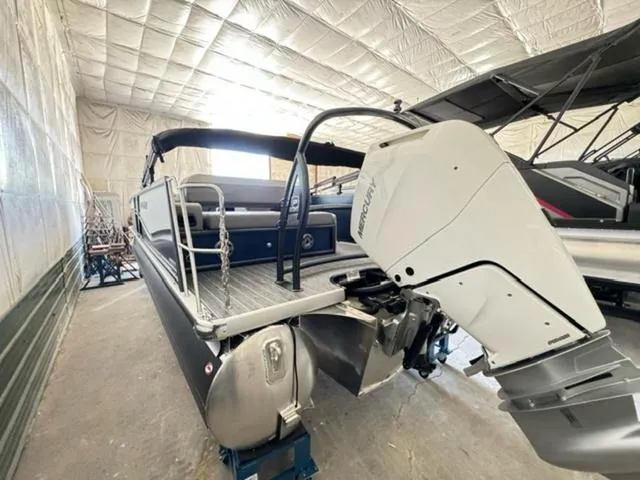Slide: The Image of 2024 Premier 250 Solaris RL pontoon boat with Mercury outboard motor in storage facility. - 5