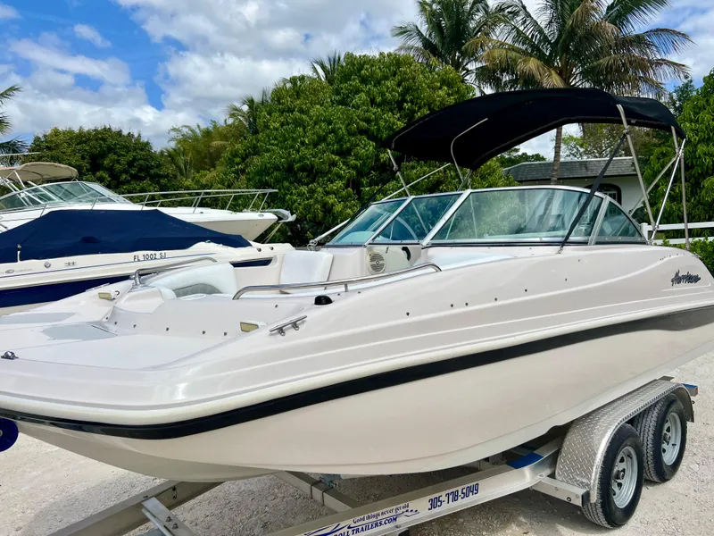 Slide: The Image of 2002 Hurricane 194 boat on trailer with canopy, parked outdoors. - 12
