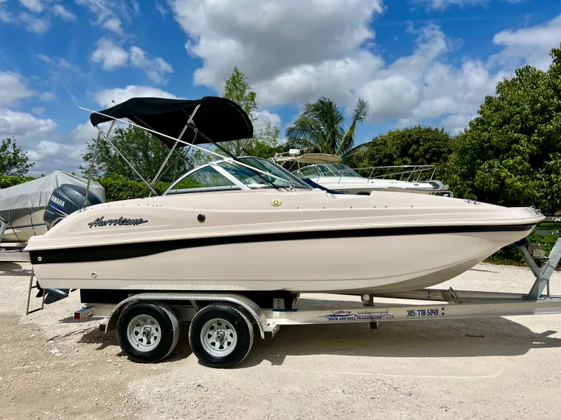 Slide: The Image of 2002 Hurricane 194 boat on a trailer under a partly cloudy sky. - 2
