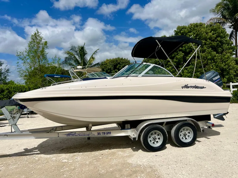 Slide: The Image of 2002 Hurricane 194 boat on trailer with canopy, parked outdoors. - 6