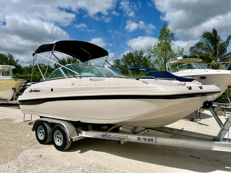 Slide: The Image of Hurricane 194 boat, 2002 model, on a trailer with a black canopy, parked outdoors. - 7