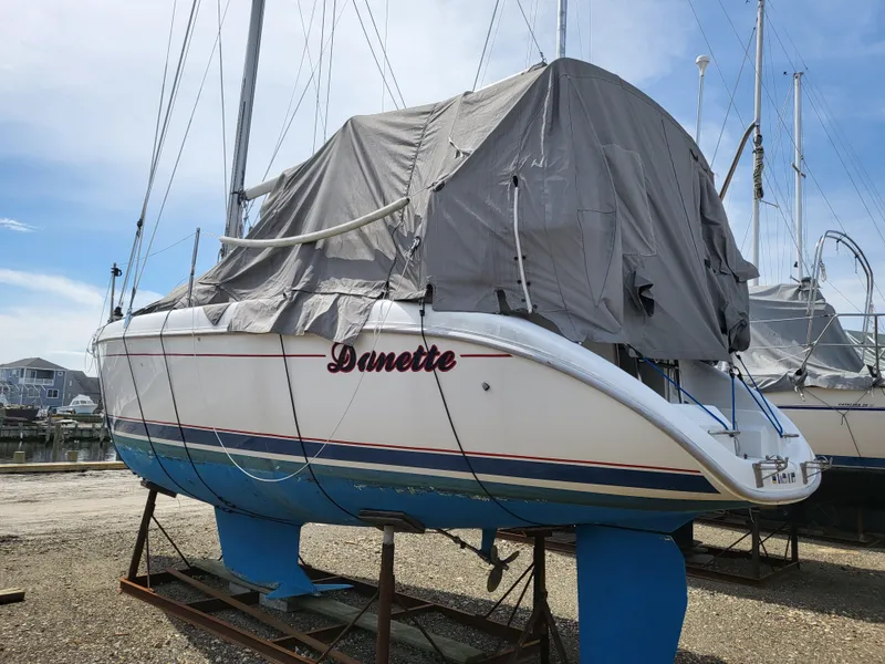 Slide: The Image of 1998 Hunter 280 sailboat on stand, covered with tarp. - 15