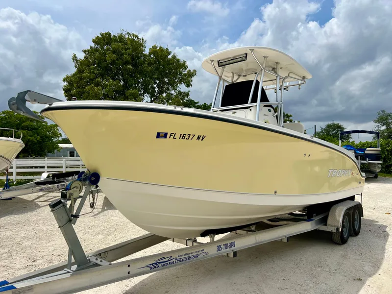 Slide: The Image of 2008 Trophy 2503 boat on trailer, yellow hull, parked outdoors. - 2