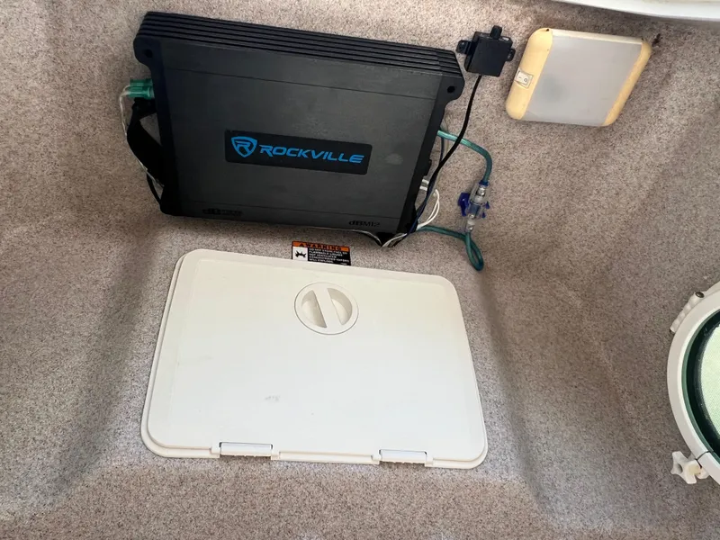Slide: The Image of 2008 Trophy 2503 boat interior with Rockville amplifier and storage compartment. - 23