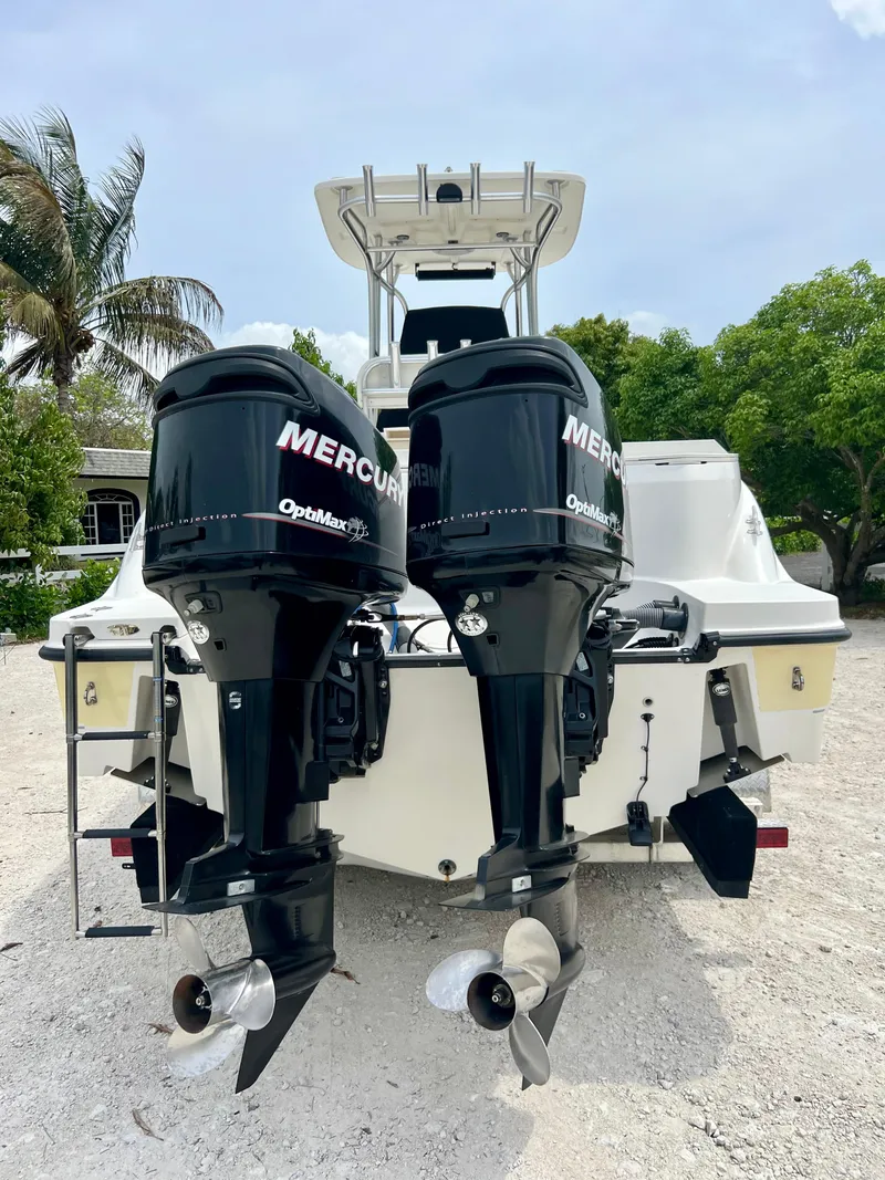 Slide: The Image of 2008 Trophy 2503 boat with twin Mercury outboard engines, parked on gravel. - 36