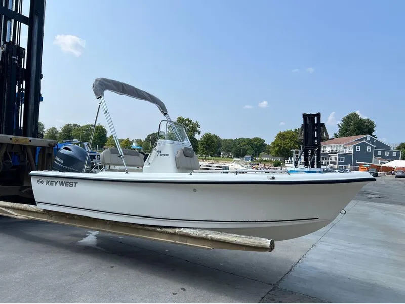 Slide: The Image of 2024 Key West 1720 CC boat on forklift at marina, clear sky background. - 17