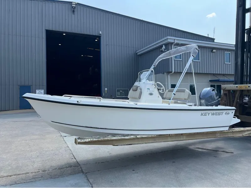 Slide: The Image of 2024 Key West 1720 CC boat displayed outside a large warehouse. - 9