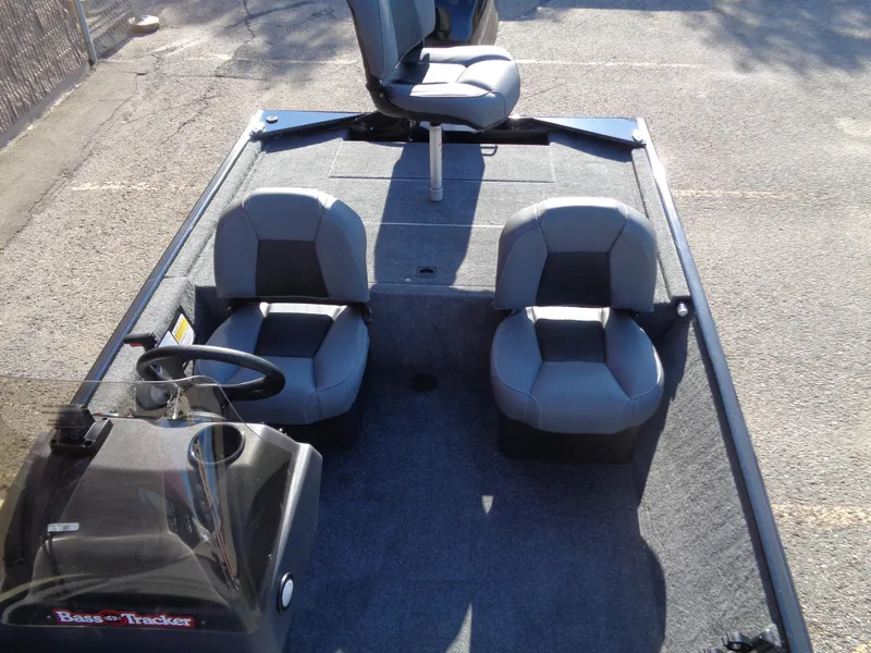 Slide: The Image of 2024 Tracker Bass Tracker Classic XL boat interior with three seats and steering console. - 5