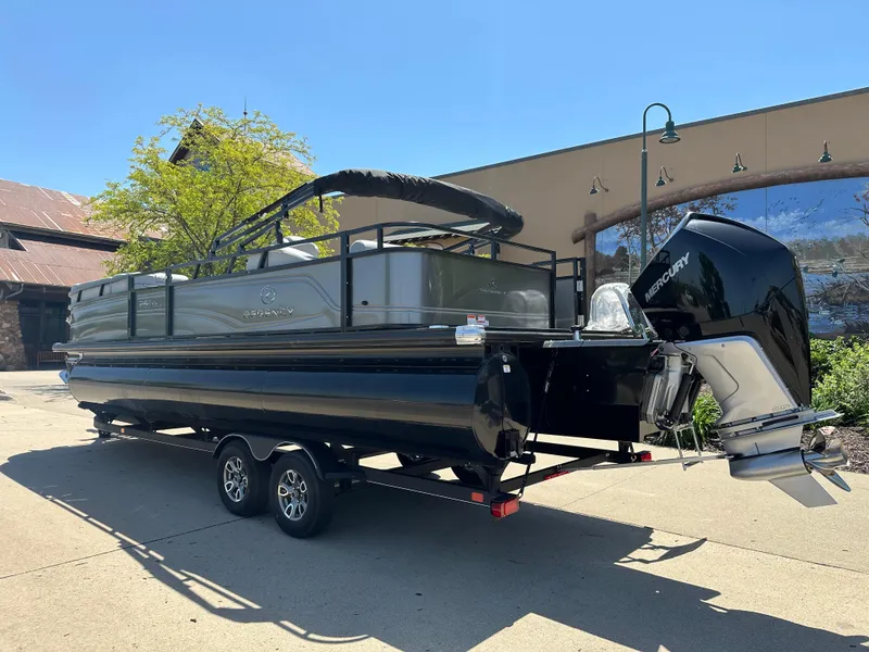 Slide: The Image of 2024 Regency 250 DL3 pontoon boat with Mercury outboard motor on trailer. - 2