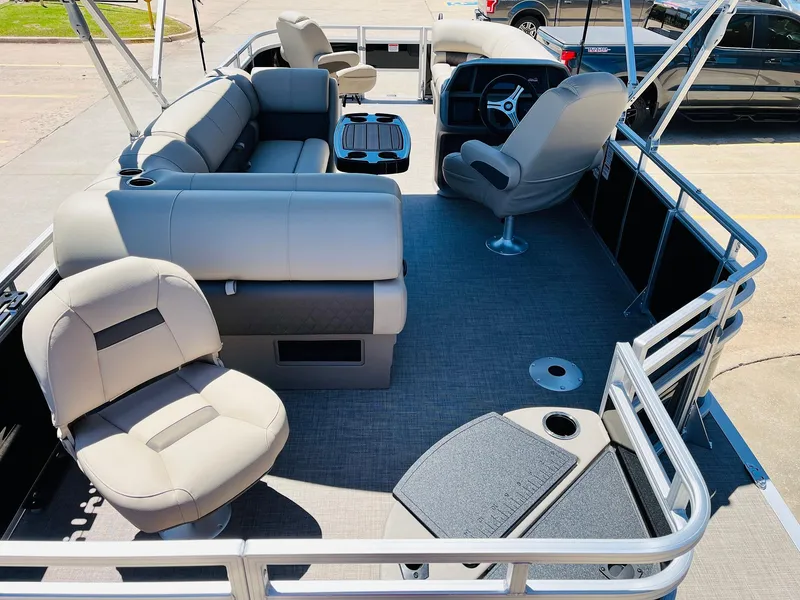 Slide: The Image of 2024 Sun Tracker SportFish 20 DLX pontoon boat interior with plush seating and steering console. - 11