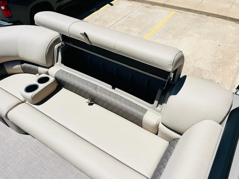 Slide: The Image of 2024 Sun Tracker SportFish 20 DLX boat interior with open storage compartment and cup holders. - 18