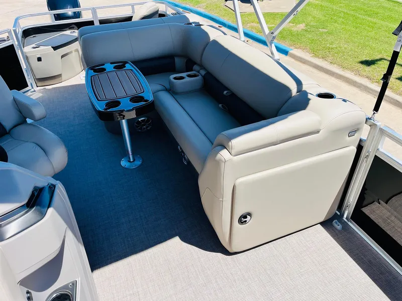 Slide: The Image of 2024 Sun Tracker SportFish 20 DLX pontoon boat with beige seating and table. - 21