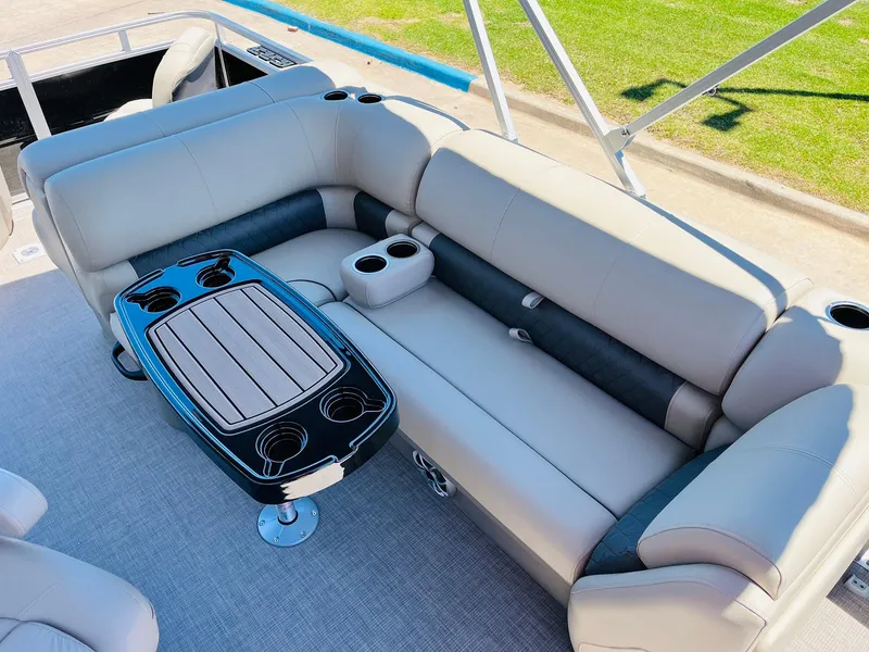 Slide: The Image of 2024 Sun Tracker SportFish 20 DLX interior with beige seating and a central table. - 23