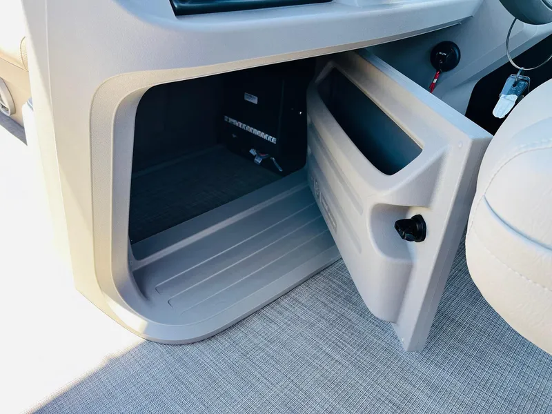 Slide: The Image of 2024 Sun Tracker SportFish 20 DLX storage compartment with open door. - 36