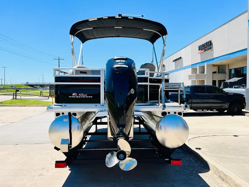 Slide: The Image of 2024 Sun Tracker SportFish 20 DLX pontoon boat, rear view, parked outdoors. - 6