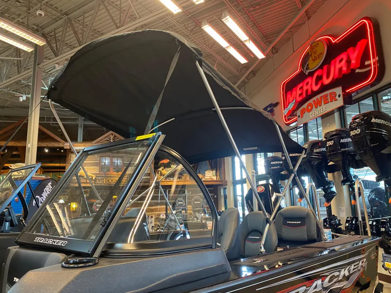 Slide: The Image of 2024 Tracker Targa V-18 Combo boat with canopy in showroom, Mercury sign in background. - 9