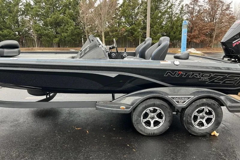Slide: The Image of 2024 Nitro Z21 XL Pro boat on trailer, sleek design, dual seats, parked outdoors. - 2