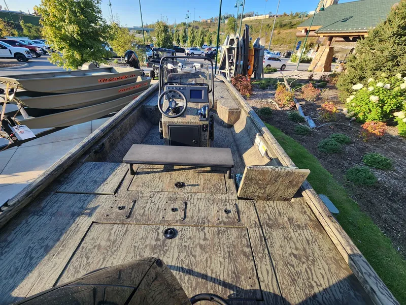 Slide: The Image of 2024 Ranger RB210 boat with wooden deck, parked outdoors in a scenic area. - 2