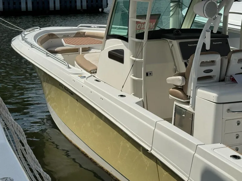 Slide: The Image of 2010 Boston Whaler 370 Outrage boat docked, featuring sleek design and spacious seating. - 1
