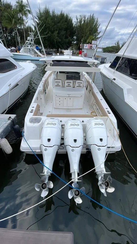 Slide: The Image of 2010 Boston Whaler 370 Outrage with triple outboard engines docked at marina. - 12