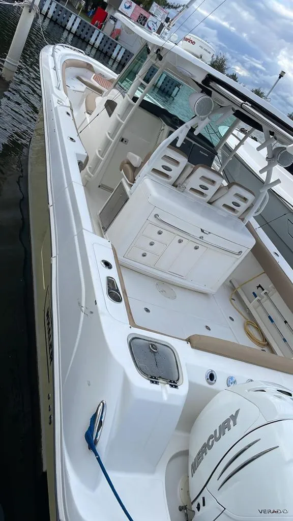 Slide: The Image of 2010 Boston Whaler 370 Outrage boat docked, featuring spacious deck and Mercury engine. - 13