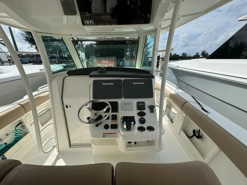 Slide: The Image of Boston Whaler 370 Outrage 2010 helm with dual Raymarine displays and beige seating. - 5