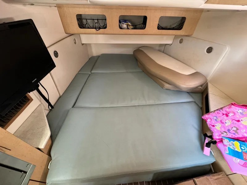 Slide: The Image of Interior cabin of a 2010 Boston Whaler 370 Outrage with cushioned seating and a TV. - 8