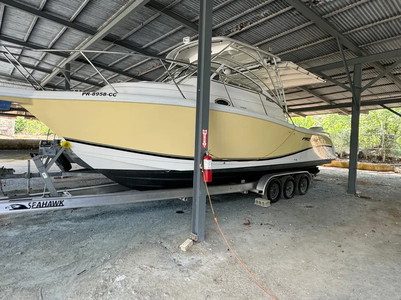 The Image of 2005 Pro-Line 32 Express boat on trailer under metal shelter. - 0