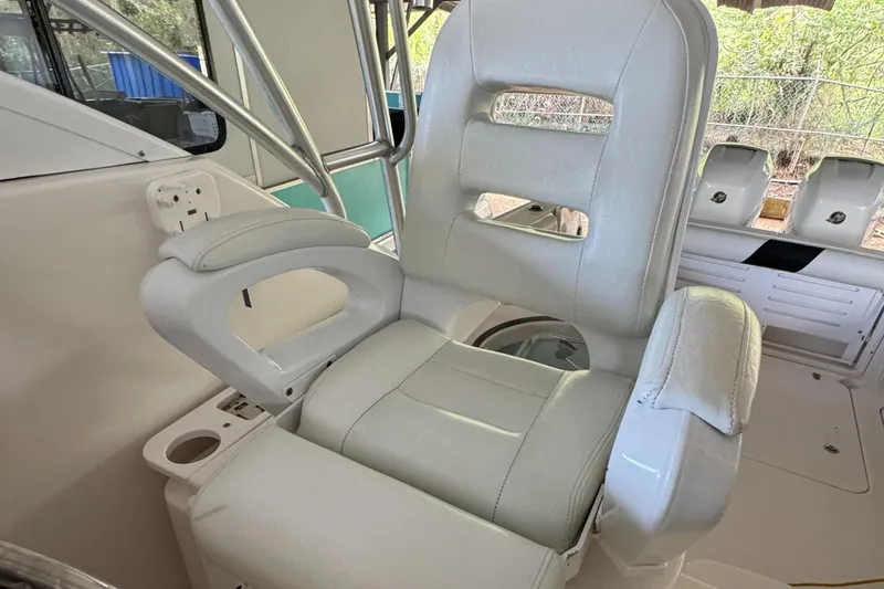 Slide: The Image of Captain's chair on 2005 Pro-Line 32 Express boat, featuring white leather upholstery and armrests. - 3
