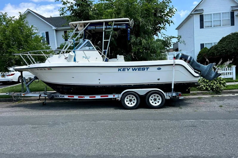 The Image of 2005 Key West 2300 WA boat on a trailer in a residential area. - 0